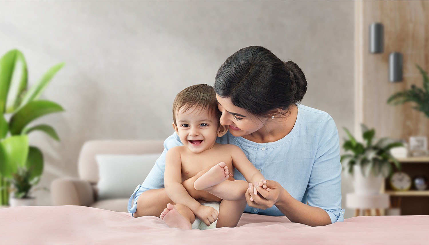 Mother laughing with her baby on the bed