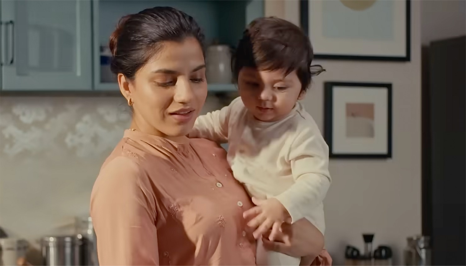 Mother holding her baby in the kitchen