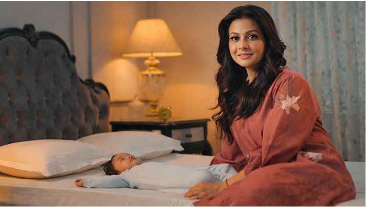 Actress in a bedroom setting for the diaper campaign