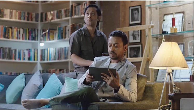 Campaign still, colleagues reviewing a tablet by a bookshelf